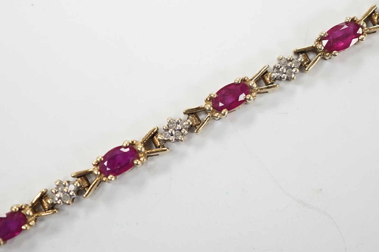 A modern 375 yellow metal, ruby and diamond cluster set line bracelet, 19cm, gross weight 7.6 grams. Fair condition.
